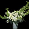 A tall, sculptural arrangement of white blooms with fresh green accents makes