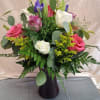 Soft pink and creamy white roses mingle with striking purple irises and