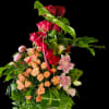 Deep red roses stacked at the peak give this tall flower arrangement
