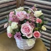 Rounded mix of pink, white, purple roses, spray roses, mini carnations, daisies