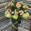 Peach gerbera daisies, lime-green roses and cream mini carnations arranged in a