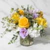 Low glass vase of yellow roses, lavender lisianthus, white stock, and yellow alstroemeria