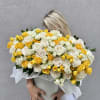 Large bouquet of yellow and white roses in a white container