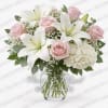 Pink roses and white lilies in a clear glass vase