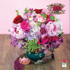 Pink and red mixed flower arrangement in a teal vase