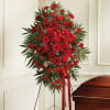 Vivid red carnations, gerbera daisies and roses with white fillers and lush