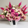 Pink and cream floral arrangement in a white vase