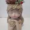 Ceramic girl planter with succulent arrangement on top