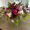 Mixed bouquet of pink, white, and purple flowers in a clear glass vase