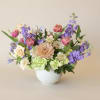 Spring Sonata is a premium garden-style centerpiece featuring green hydrangea, peach mum