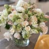 Bouquet of pale roses and white snapdragons in a glass vase