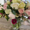 Mixed bouquet of pink, white, and yellow flowers in a clear glass vase