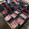 Assorted roses arranged in square gift boxes on a pallet