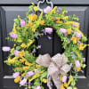 Floral wreath with purple and yellow blooms on a black door