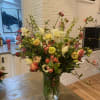 Mixed bouquet of white, pink, and yellow flowers in a clear glass vase