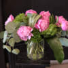 Clustered pink peonies take center stage in this cheerful birthday bouquet, their