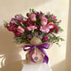 Pink/purple roses, carnations and purple accents in a lush, hand-tied bouquet with