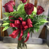 Truly a classic set up, six long stemmed red roses, lush greens