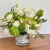 White and green floral arrangement in a glass vase