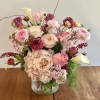 Pink and cream floral arrangement in a glass vase