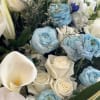 Bouquet of white roses, blue ranunculus, and white calla lilies