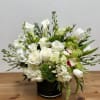 White and green floral arrangement in a black vase