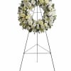 Delivered on an easel, a standing wreath comprising fresh flowers such as