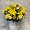 Yellow flowers arranged in a white pitcher vase