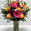 A bright a colorful collection of spring florals with orange roses, lavender
