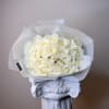 Bouquet of cream white roses wrapped in translucent paper