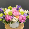 Pink and purple bouquet in a white vase