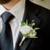 White boutonniere pinned to a black suit jacket