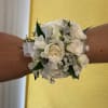White rose wrist corsage with silver ribbon and green accents
