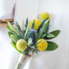A fresh, textural boutonniere featuring bold blue thistle and golden billy balls