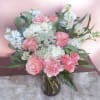 Soft pink roses and ruffled white carnations mingle with cloud-like hydrangeas in
