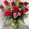 A tall, layered bouquet of red and pink roses that reads like