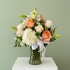 Soft peach, blush, and ivory roses layered with a billowy white hydrangea