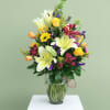 Large white lilies take center stage in this cheerful Mother's Day bouquet