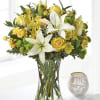 Yellow roses and white lilies arranged in a clear glass vase
