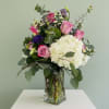 A full, garden-style bouquet built around a voluminous white hydrangea makes this