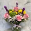Soft pink roses and bright yellow daisy-like chrysanthemums meet airy white asters