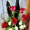 Lush red roses arranged with lovely white spray roses arranged in a