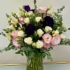 Bouquet of pink, white, and deep purple flowers in a glass vase
