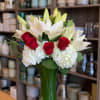An elegant composition of white lilies, roses, and hydrangea, creating a timeless