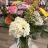 Mixed bouquet in a clear glass vase with pink, white, yellow, and orange flowers