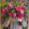 Large mixed bouquet of pink, purple, and orange flowers in a glass vase