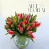 VIbrant and elegant arrangement featuring coral tulips, beautifully arranged in a clear
