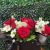 A custom black bag with vibrant, color blooms, featuring red roses, delicate