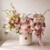 Large pastel bouquet of pink and white flowers in a ribbed white vase