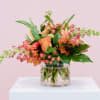 A Vibrant mix of coral and pink snapdragons, roses, hypericum and Gerbera